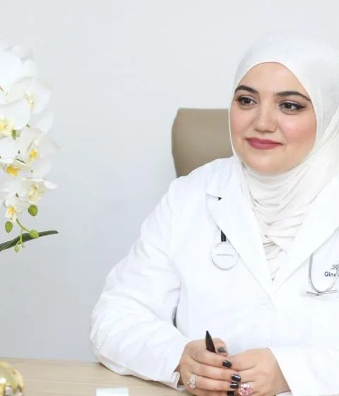 Dr. Aytən Abdullayeva ağ həkim xalatında, iş masası arxasında
